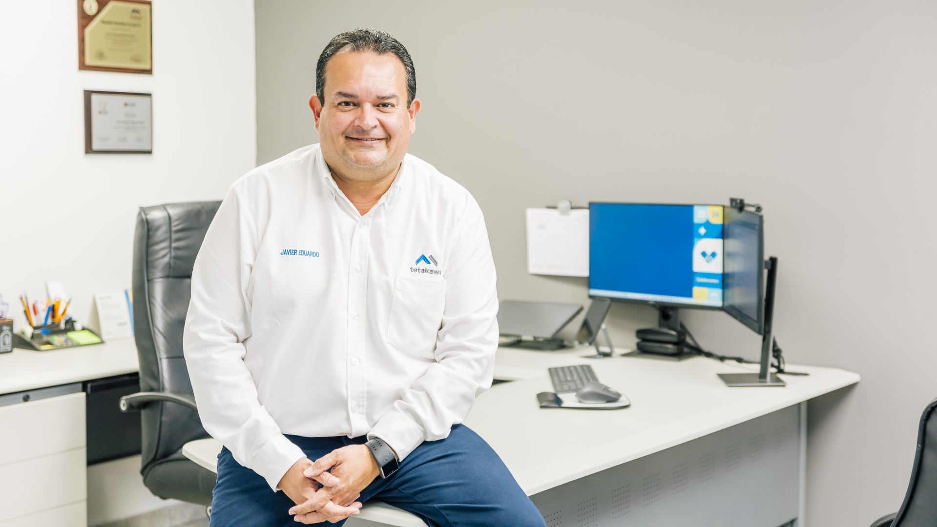 Office employee sitting on edge of desk
