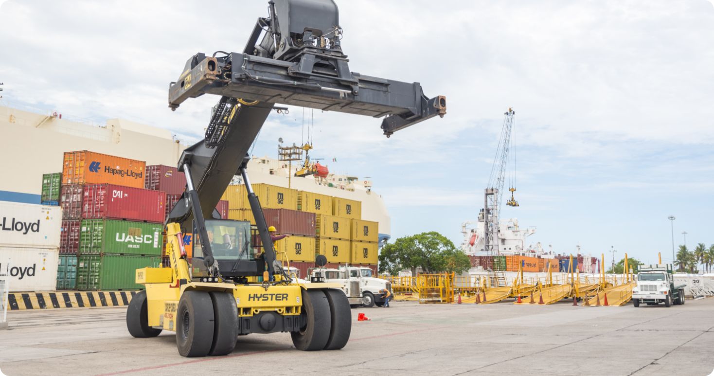 Large cargo handler moving shipping containers at the Port of Mazatlán, Mexico.