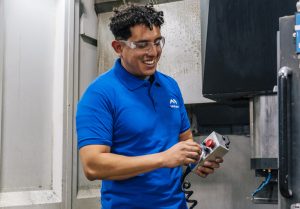 Smiling manufacturing worker operating machinery in Mazatlán, Mexico.