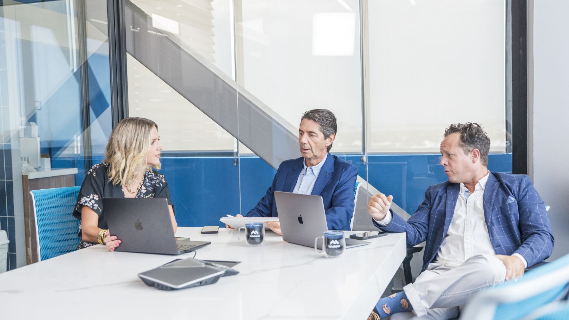 Three people sitting in conference room