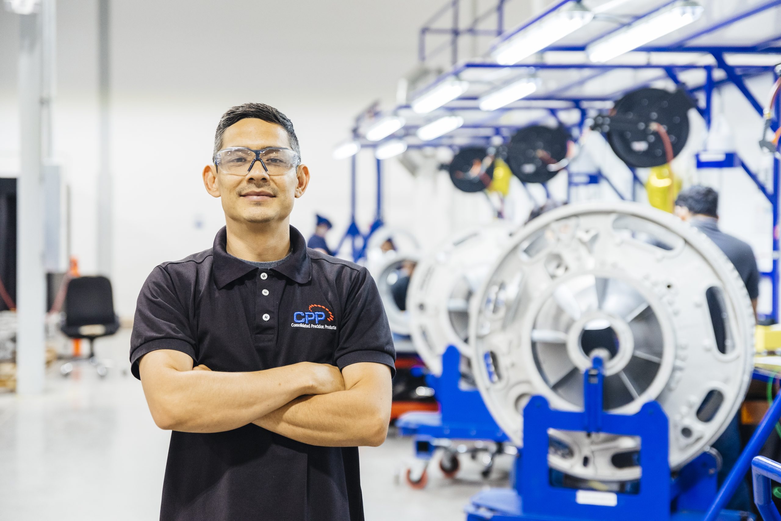 Skilled manufacturing worker at CPP Mazatlán facility, standing in front of aerospace components.